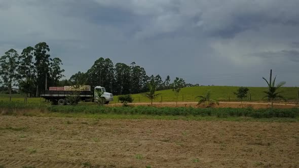 Drone footage following a lumber truck driving down a rural road