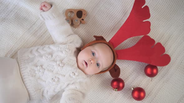 Six Month Old Baby Wearing Festive Christmas Reindeer Antlers. 
