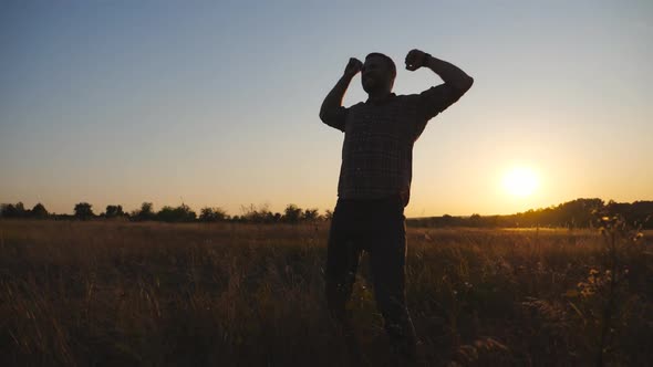 Happy Guy Outstretching Arms Up at Summer Meadow