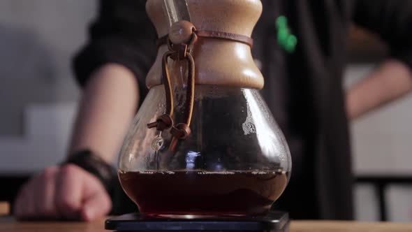 Barista waiting while coffee dropping in a chemex