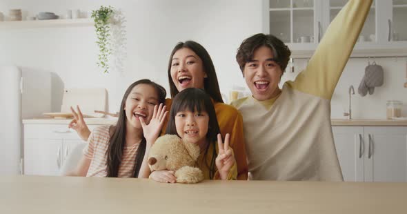 Happy Family of Four Smiling Together at Kitchen Posing to Camera Recording Video Portrait for