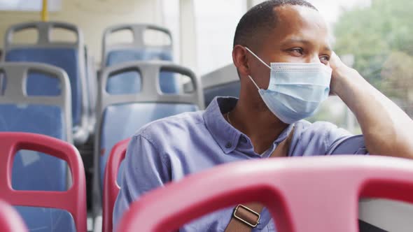 African american man with face mask sitting in bus