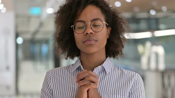 Hopeful African Businesswoman Praying Holding Hands Together