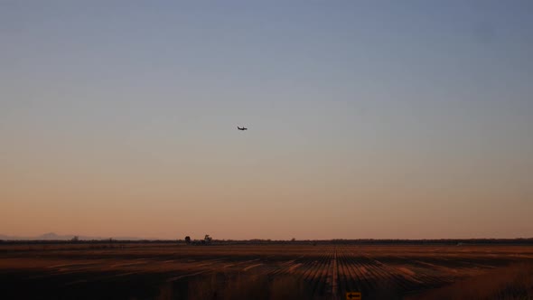 A plane flying over the fields around Sacramento in slow motion.