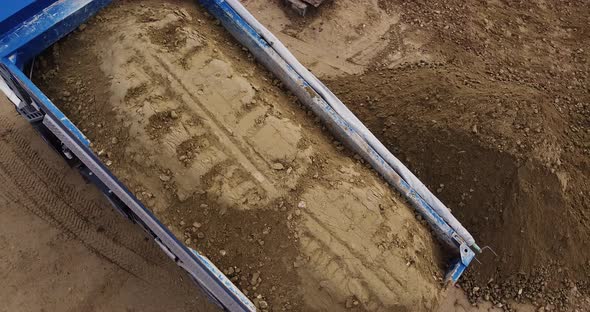 Dump Truck Unloading Soil or Sand at Construction Site