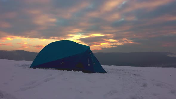 Hiker in shorts getting out from tent, enjoying cold weather