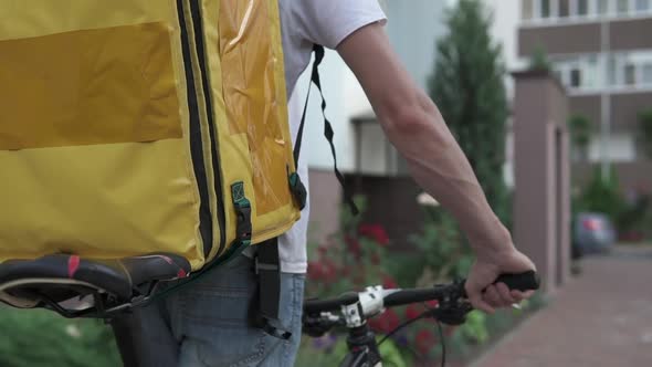 Pizza delivery, sushi to home on a bicycle in a yellow thermo backpack