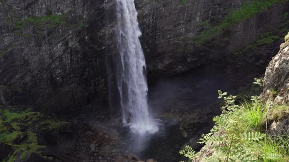 Waterfall Cascading Down Cliff To River