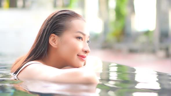 Young asian woman enjoy around outdoor swimming pool for leisure