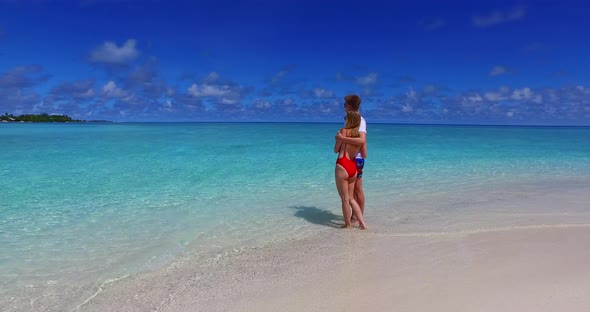 Beautiful lady and man in love dating on vacation enjoy life on beach on sunny white sandy 4K backgr