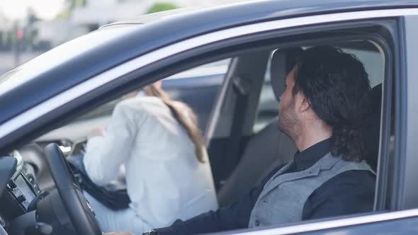 Elegant Man on Driver's Seat in Car Watching Woman Walking Out Leaving