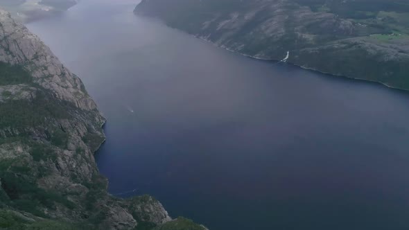 Aerial Slomo Titlting Up revealing a Norwegian Fjord close to the Preikestolen with Clouds and Fog i