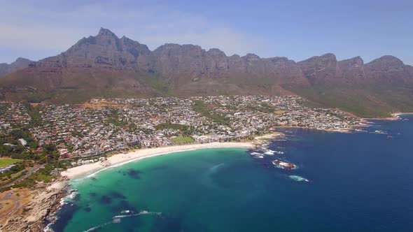 Aerial travel drone view of Camps Bay beach, Cape Town, South Africa.