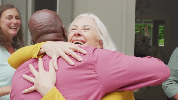 Animation of happy caucasian senior woman embracing african american male friend