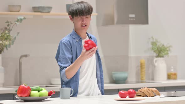 Young Asian Man Playing with Vegetables and Dancing in Kitchen