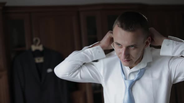 Handsome Groom Fixes His Shirt with Bow Tie. Wedding Morning. Businessman