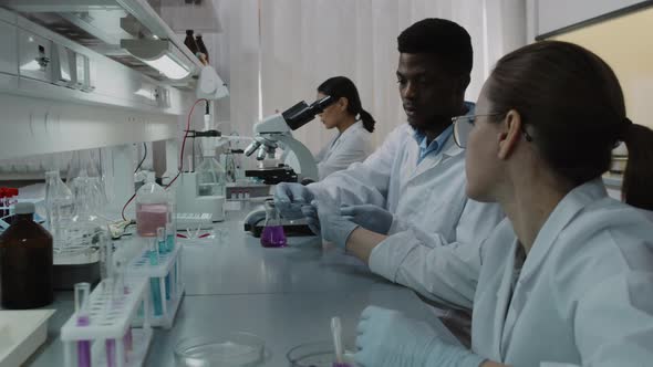 Three Chemists Working on Research in Lab