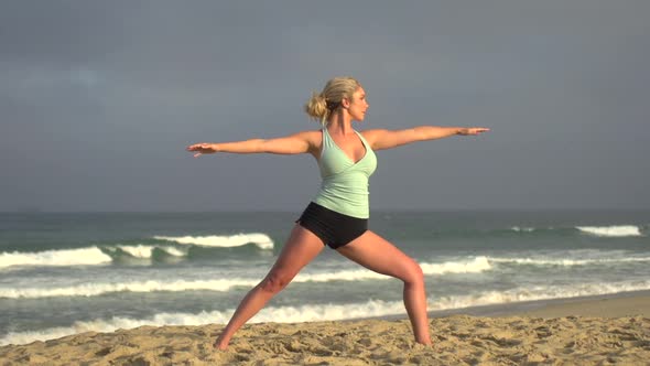 A young attractive woman doing yoga on the beach.