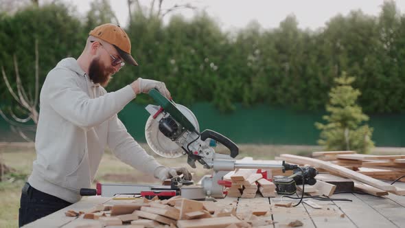 Close Up Shot of Man Cutting Wood Using Table Saw on Construction Site