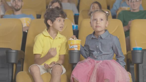 Absorbed Children Watching Film in Cinema and Eating Popcorn, Portrait of Carefree Middle Eastern