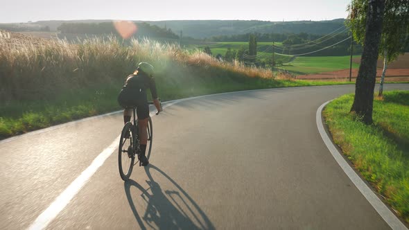 Professional triathlete speeding on bicycle from hill