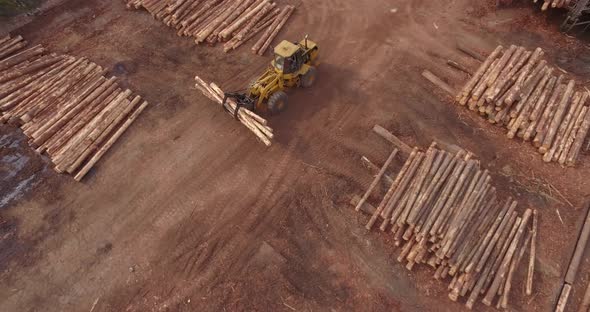 4K Aerial Shot Descending Towards and tracking Timber Logging Front loader Vehicle