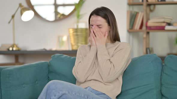 Young Woman Sitting and Crying on Sofa 