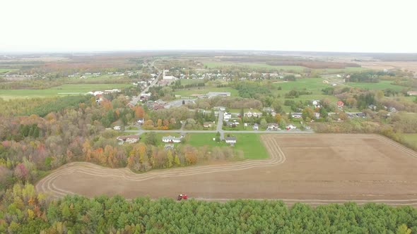 Small city aerial drone footage with houses and field on the harvest season