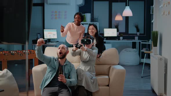 Workmates Playing Video Games with Controller on Console