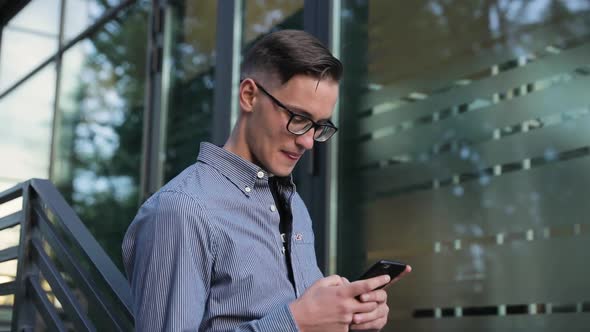 Man Using Mobile Phone Near Office Building