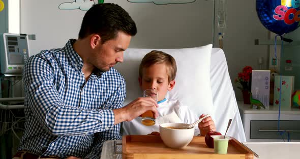 Father feeding breakfast to his son
