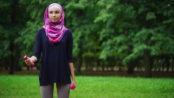 Muslim Girl Exercising with Dumbbells Outdoor