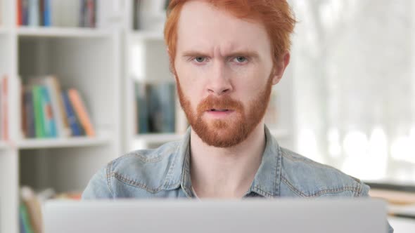 Thumbs Down By Casual Redhead Man Looking at Camera at Work