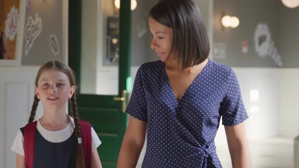 Slider Shot of Afroamerican Female Teacher and Preteen Girl Pupil Walk in School Corridor and Talk