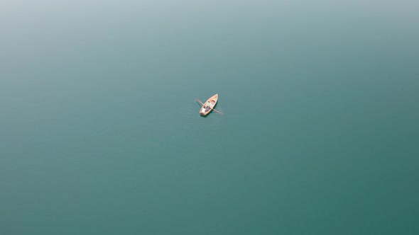 Aerial View Lone Wooden Boat in the Middle of Water Surface of a Mountain Lake