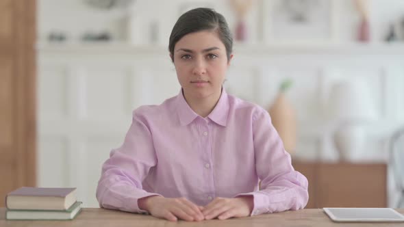 Indian Woman Looking at Camera while Sitting in Office