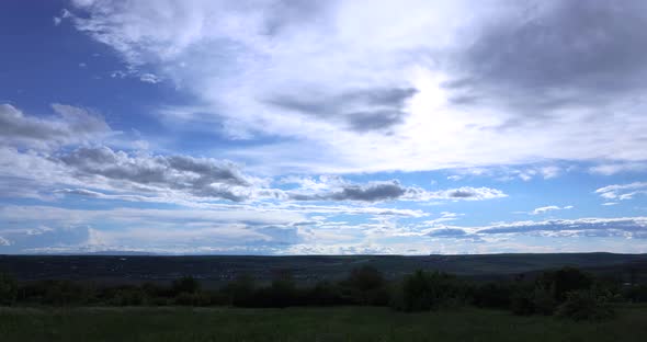 Beautiful clouds over green landscape - time lapse