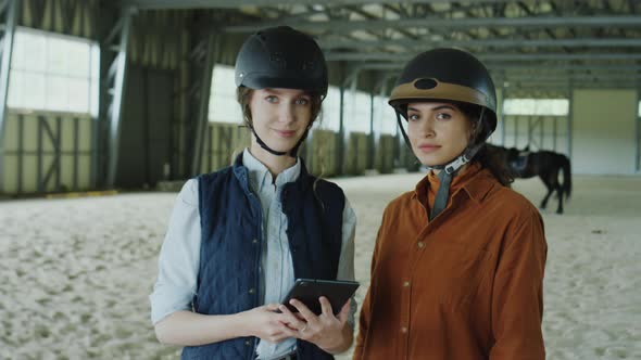 Portrait of Two Female Horse Riders with Tablet