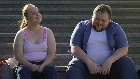 Cute Fat Couple Talking and Laughing, Sitting on Stairs, Relationship Beginning