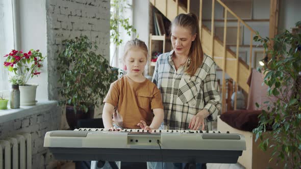 Music Teacher Teaches a Young Student How to Play the Electronic Piano
