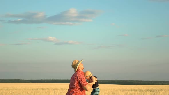 Young Father Playing with Son on Wheat Field