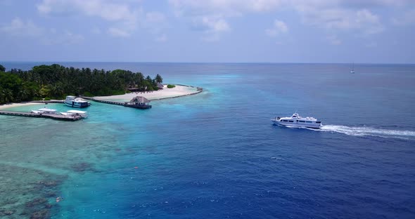 Luxury fly over abstract shot of a sandy white paradise beach and aqua blue water background