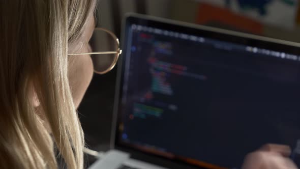 Woman developer coding on laptop computer. Close-up view face by side