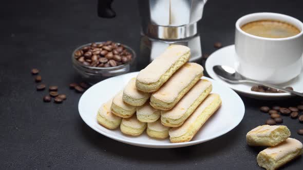 Italian Savoiardi Ladyfingers Biscuits and Cup of Coffee on Concrete Background