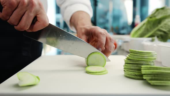 Close-up: The chef cuts the zucchini finely with a knife