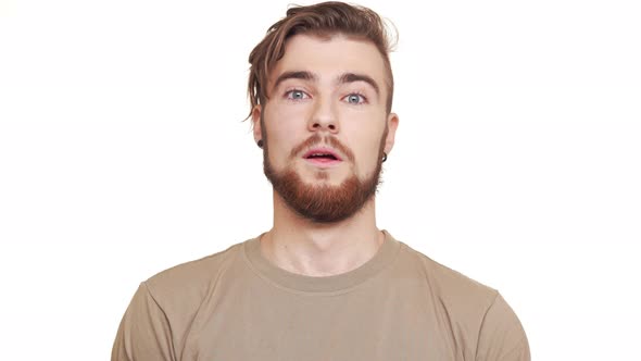Handsome Young Bearded Caucasian Male Standing in Amuzement and Laughing on White Background