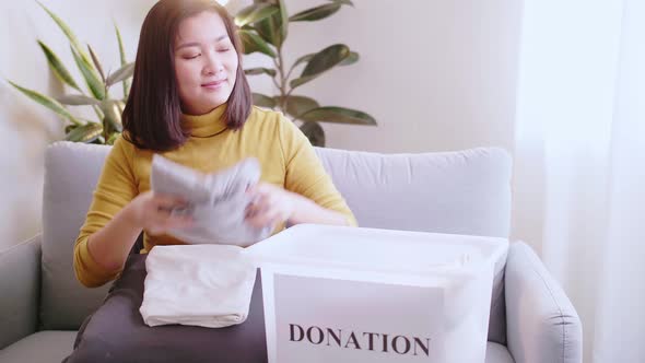 Woman pressing phone using a credit card to pay online to reserve donation box delivery. Concept cam
