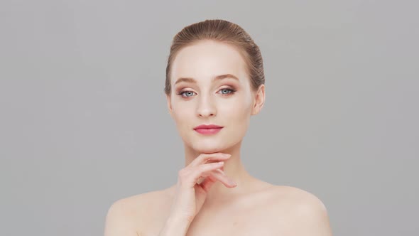 Studio portrait of young, beautiful and natural woman over grey background.