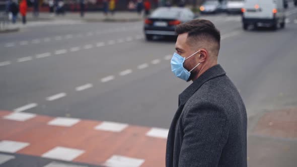 Guy wearing safety mask and walking on a road. Responsible behavior during world covid-19 pandemic.