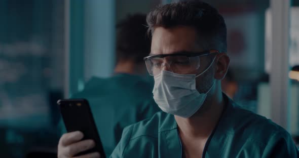Male Doctor Unlocking Smartphone with Face Scan